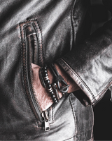 Close-up of a leather jacket with zippers on a black background