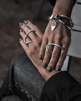 Close-up of hands wearing silver rings and bracelets on a blurred background