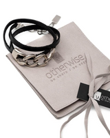 Jewelry set with black cord and silver chain on a branded pouch, displayed on a white background.