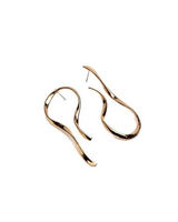 A pair of abstract, wavy open hoop earrings in a polished gold-tone finish, displayed on a clean white background.