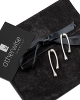 Modern geometric droplet earrings displayed on a black suede pouch; silver-tone, lightweight, irregular droplet shape.