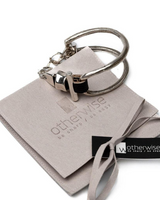 Silver keychain on a branded card with 'otherwise' branding.