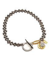 Bracelet with metal beads and gold charm on a white background