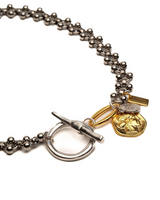 Bracelet with gold heart charm and toggle clasp on a white background