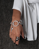Chunky silver-plated anchor link necklace and bracelet set worn on a model's wrist, showcasing large links and a unique charm.