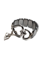 Metallic bracelet with heart charm on a white background