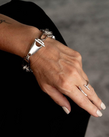 Multi-layer wrap bracelet featuring a Great White shark tooth pendant and heavy metal chains on a model's wrist.