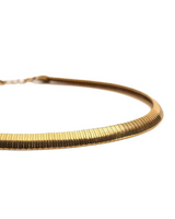 A close-up of a gold-toned snake chain necklace on a plain white background.