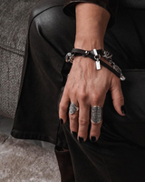 Chunky coin charm bracelet featuring a heavy-duty metal chain, leather closure, and dangling antique-style coins.