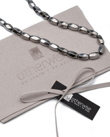Layered leather and metal stacked necklaces set featuring polished metallic accents, hematite beads, and a blue stone detail.