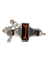 Chunky silver-plated bracelet featuring a rectangular amber crystal centerpiece and adjustable links for sizing.