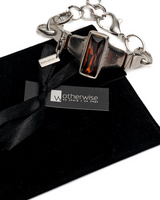 Chunky silver-plated necklace and adjustable bracelet with red Austrian crystals, displayed in a black suede pouch.