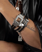Black leather wraps around the wrist twice, featuring a hammered metal clasp, padlock charm, and silver accents.