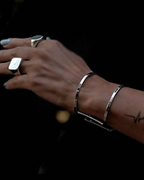 Chunky minimalist metallic cuffs featuring a wide flat design and an open double band. Adjustable silver finish.
