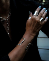 Chunky minimalist metallic cuff bangle set worn on a hand, featuring a wide flat cuff and open double band design.