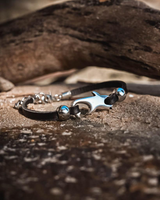 Chunky black leather anklet featuring a sterling silver plated shark charm and silver beads, layered for an edgy look.