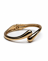 Chunky gold cuff bangle featuring a curved, open design with a polished finish, ideal for stylish stacking.