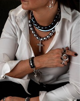 Layered choker set featuring silver and gunmetal hematite beads with a leather choker, styled with a white blouse.