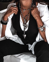 Long chunky heart ball chain necklace with sculpted heart pendant, worn with a black vest and white blouse, layered for effect.