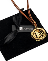 Natural leather strands with a hammered gold-plated metal hoop necklace, presented in an elegant black suede pouch.