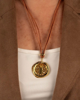 Natural leather strands with a gold hammered hoop necklace worn around the neck, showcasing a unique asymmetric design.