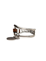 Brown leather wrap bracelet featuring oversized silver plated horse bit link and coin pendants, adjustable clasp.
