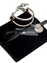 Brown leather wrap cuff bracelet featuring oversized silver-plated horse bit link and coin pendants, adjustable clasp.