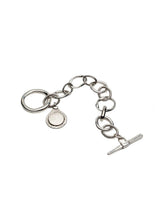 Silver asymmetrical link bracelet with a teardrop Phaistos Disc pendant and chunky T-bar toggle closure.