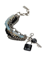 Multi-strand bracelet featuring blue moonstone beads, black glass, stainless steel chains, and lock and key charms.