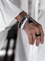 Five-strand Moonstone bracelet featuring black glass beads, agate lock and key pendant, layered with delicate chains.