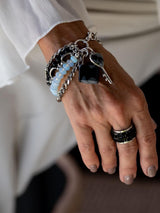 Five-strand bracelet featuring moonstone and black glass beads, with a lock and key pendant on a stainless steel chain.
