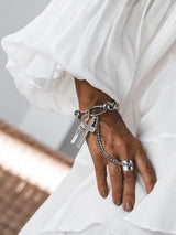 Stainless Steel Cross Hand Chain Bracelet features a large gothic cross pendant and adjustable antique silver ring, worn over a hand.