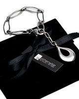 Stainless Steel Teardrop Anklet with a wavy oval link chain and a shiny teardrop pendant, displayed on a black pouch.