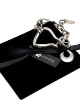 Chunky silver toggle cuff bracelet with a heavy textured design, featuring a T-bar clasp and a large drop pendant.