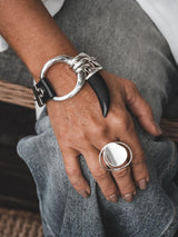 Sterling silver adjustable ring featuring an irregular large circle design, worn on a hand resting on denim.