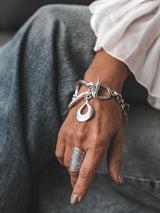 Chunky Silver Toggle Cuff bracelet on a wrist, featuring a textured heavy design and T-bar toggle clasp.