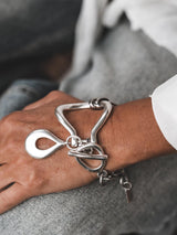 Chunky silver toggle cuff bracelet with a heavy, textured design, featuring a stylish T-bar clasp and oversized drop pendant.
