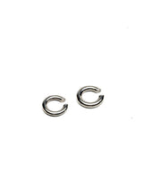 Asymmetric silver metal ear cuffs with a minimalist design, featuring two contrasting sizes for a stylish look.