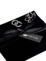 Asymmetric metal ear cuffs showcased on a black velvet pouch with a black ribbon and store tag.