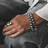 Chunky metallic hematite wrap bracelet with 12mm beads and silver accents, worn stacked on the wrist.