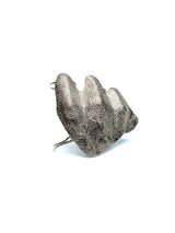 Chunky, sculptural knuckle ring in irregular folded zinc alloy, featuring a textured silver surface and avant-garde design.