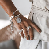 Connected Chevalier Ring Set featuring two wide brass bands linked by an antique silver chain, adorned with round charms.