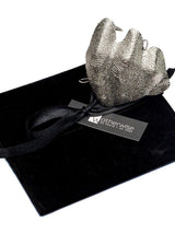 Sculptural, chunky knuckle ring in textured zinc alloy with an irregular pleated design on a black velvet background.