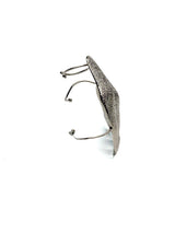 Sculptural folded metal knuckle ring with an irregular, textured design, showcasing a chunky, avant-garde style.